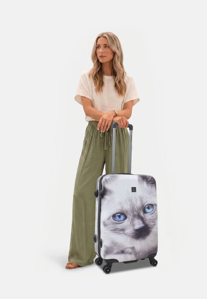 Saxoline White Cat middelgrote harde reiskoffer met grijs-witte kattenprint, vrouw poseert met de koffer op witte studioachtergrond