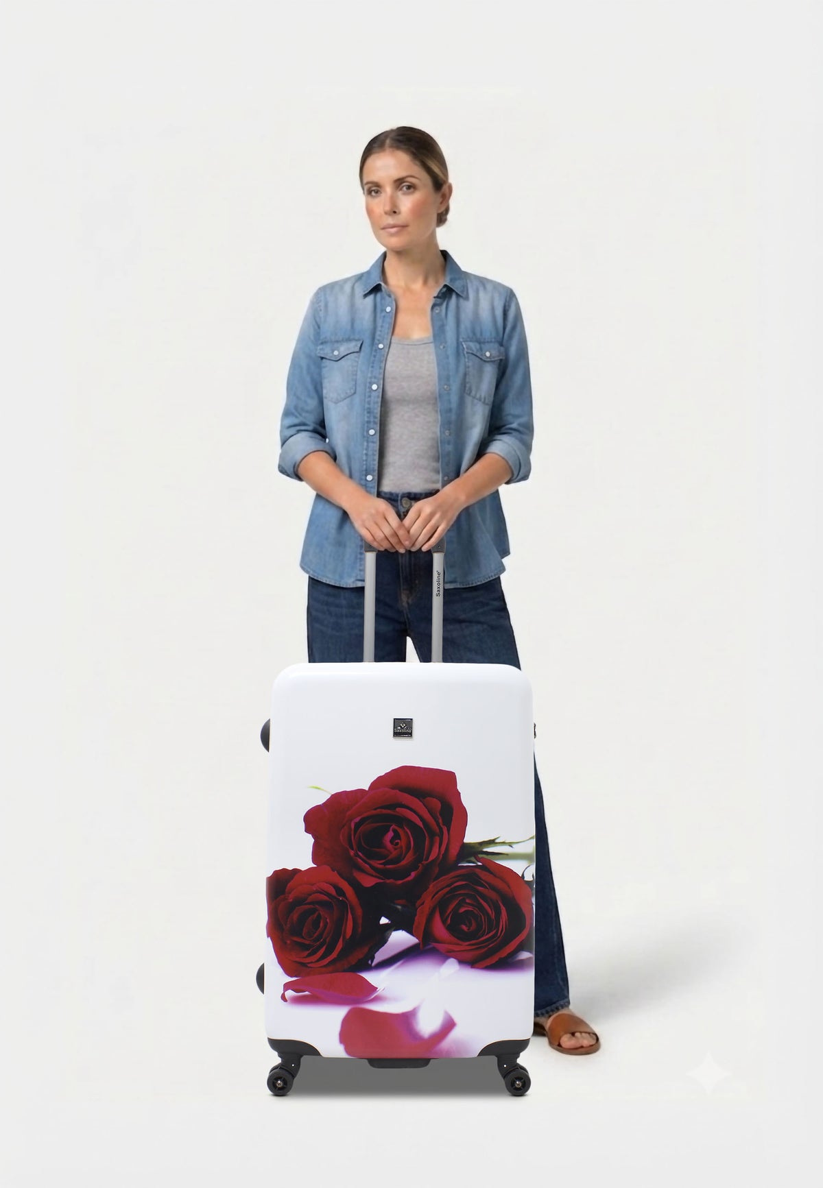 Saxoline Red Roses driedelige harde kofferset in wit met rode rozenprint, vrouw poseert met de grote koffer op witte studioachtergrond