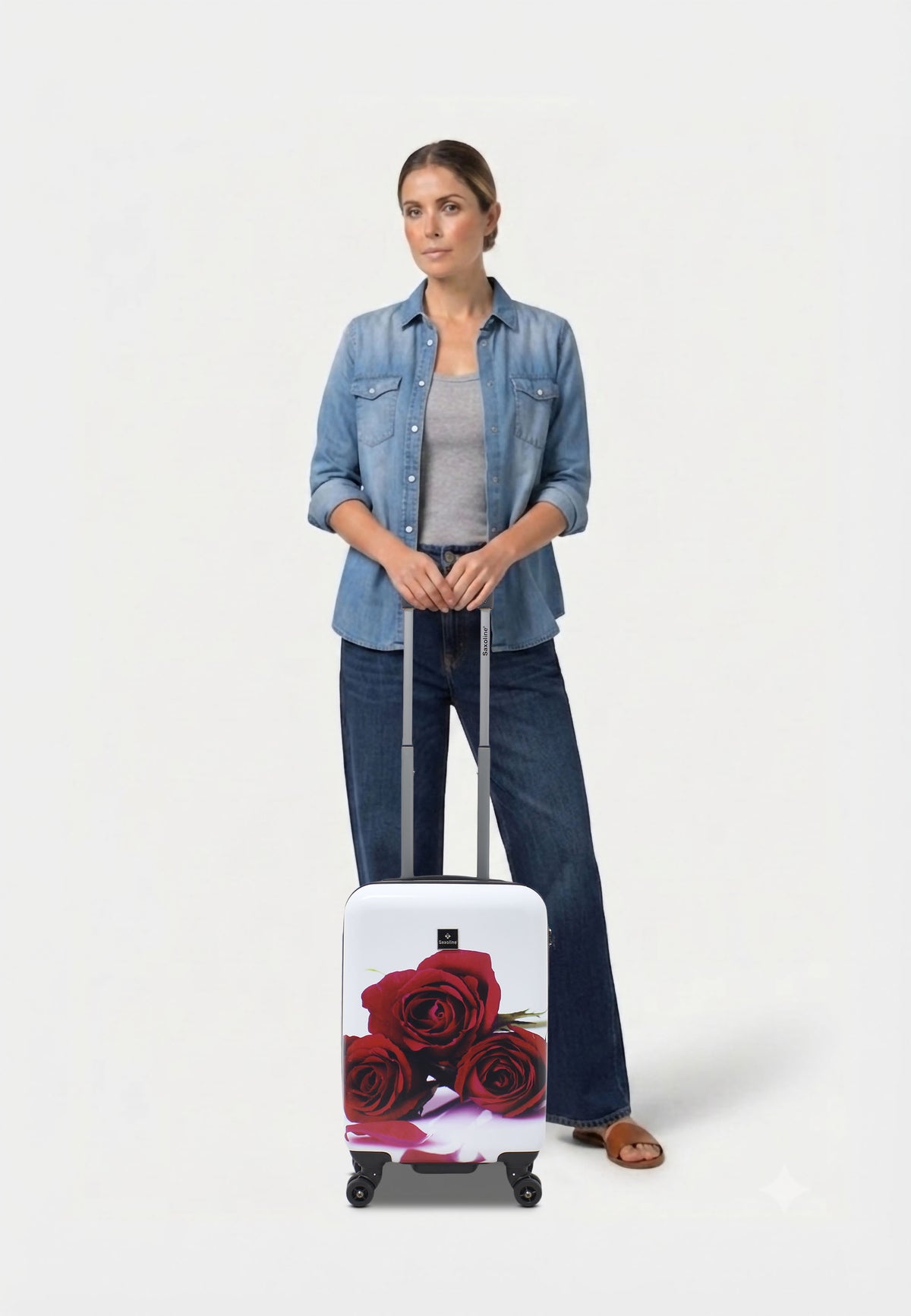 Saxoline Red Roses harde handbagagekoffer in wit met rode rozenprint, vrouw poseert met de koffer op witte studioachtergrond