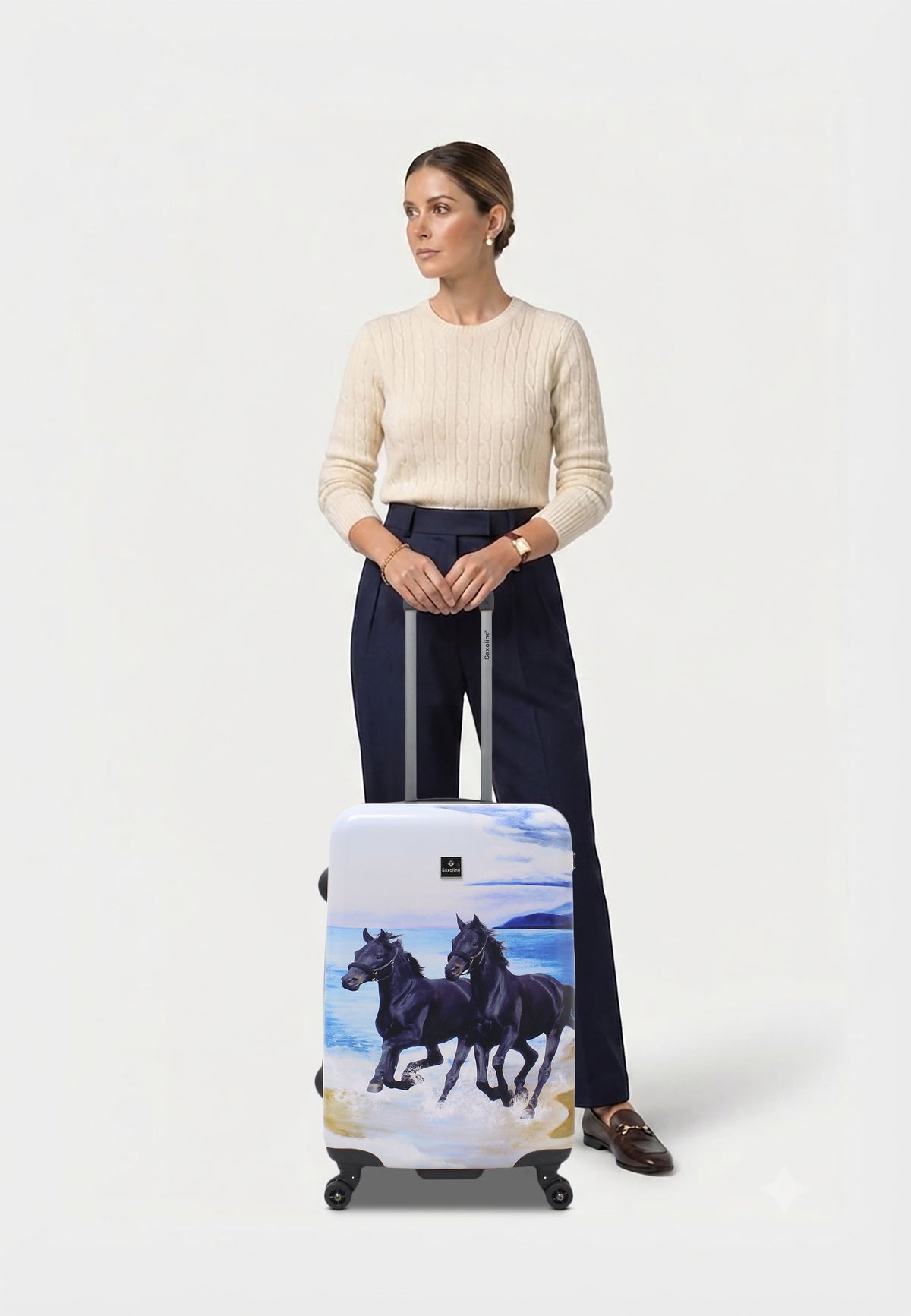 Saxoline Black Horse middelgrote harde reiskoffer in wit met zwarte paardenprint, vrouw poseert met de koffer op witte studioachtergrond
